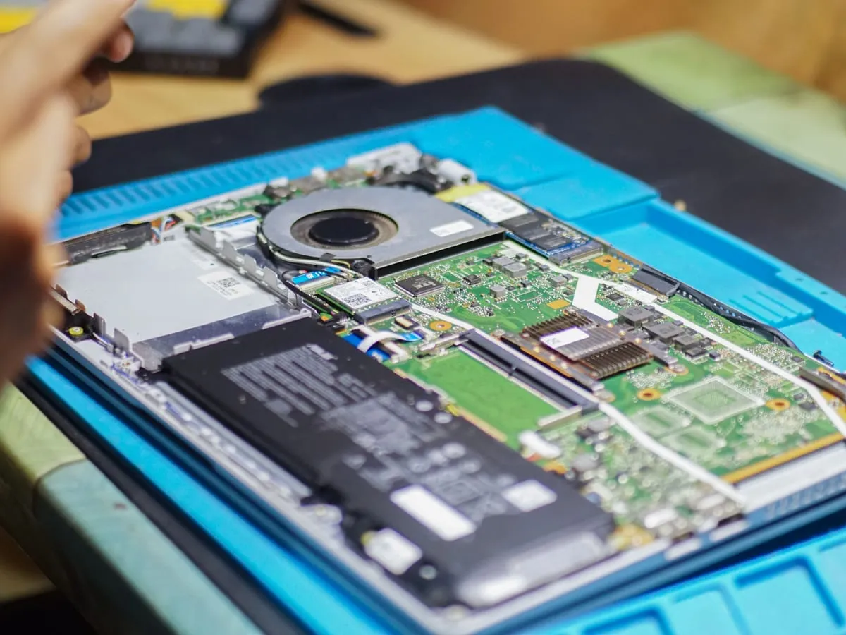 Teknisi LapCare sedang membersihkan dan mengganti thermal paste laptop